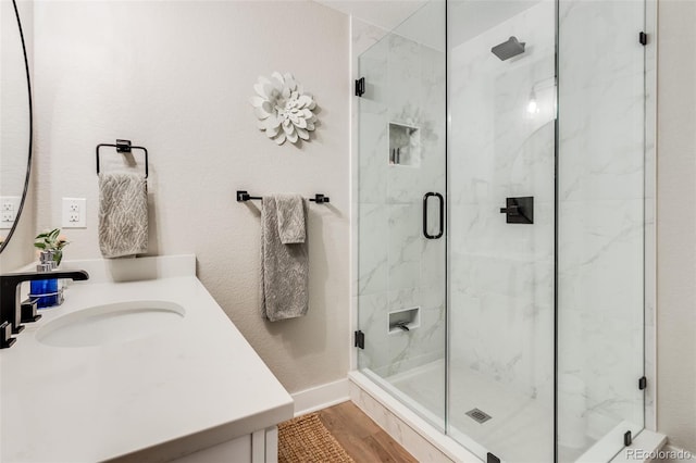 bathroom featuring vanity, wood-type flooring, and walk in shower