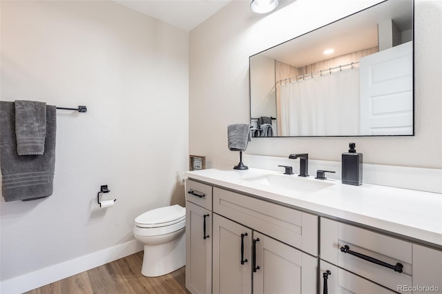 bathroom with a shower with shower curtain, vanity, toilet, and hardwood / wood-style floors