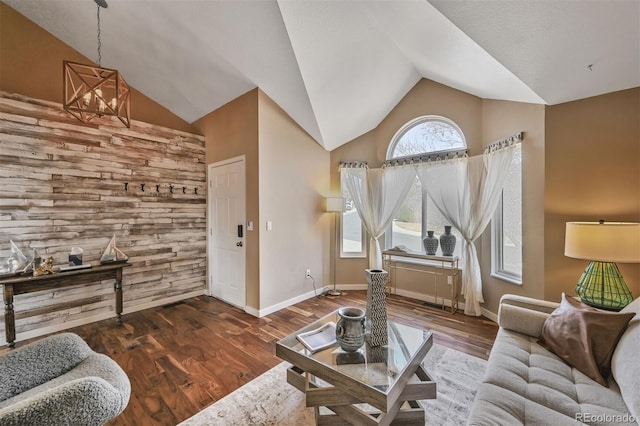 living area featuring lofted ceiling, wood finished floors, and baseboards