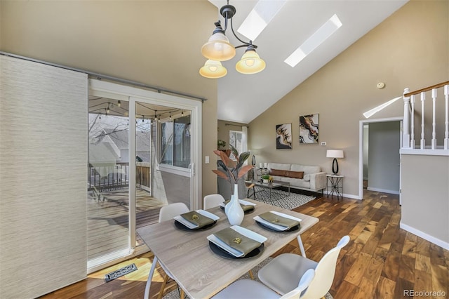 dining space with wood finished floors, baseboards, high vaulted ceiling, an inviting chandelier, and a skylight