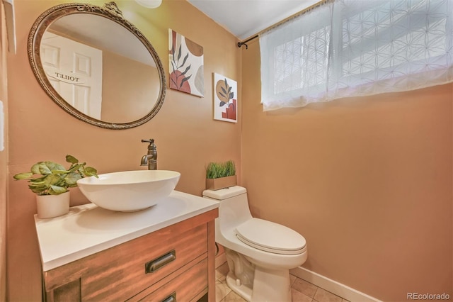 half bathroom featuring tile patterned floors, toilet, and vanity