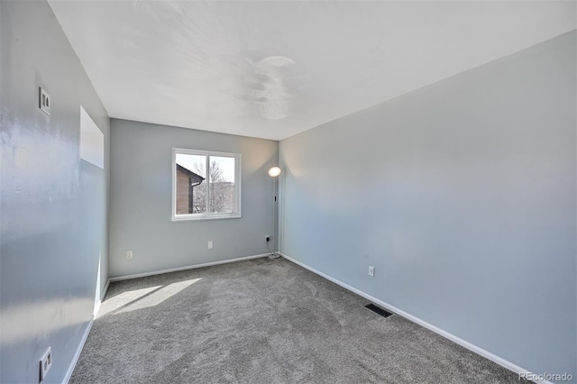 empty room with visible vents, baseboards, and carpet