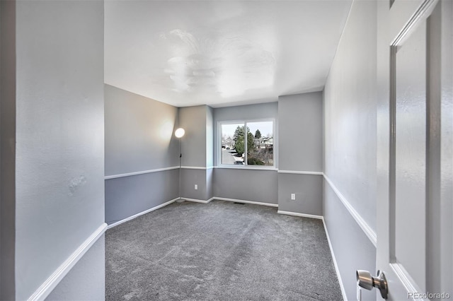 spare room featuring baseboards and carpet