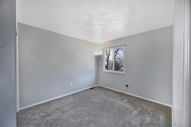 empty room with visible vents, baseboards, and carpet