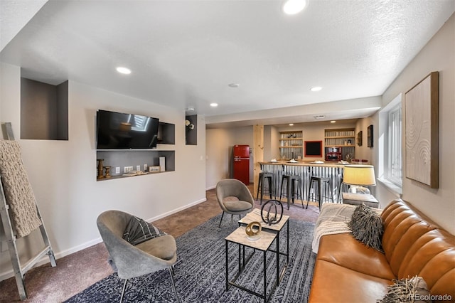 carpeted living room with recessed lighting, indoor wet bar, baseboards, and a textured ceiling