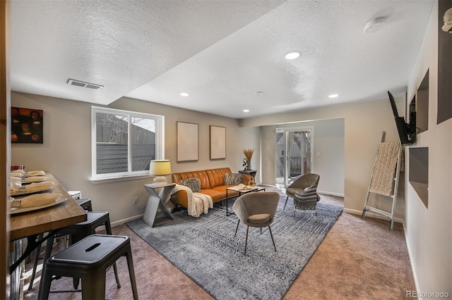 carpeted living area featuring recessed lighting, visible vents, baseboards, and a textured ceiling