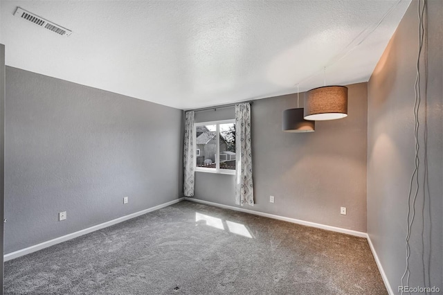 carpeted empty room with visible vents, a textured ceiling, baseboards, and a textured wall