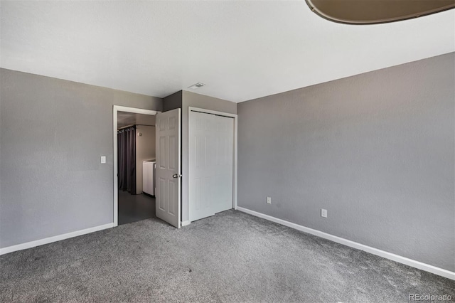 unfurnished bedroom with carpet, visible vents, baseboards, washer / dryer, and a closet