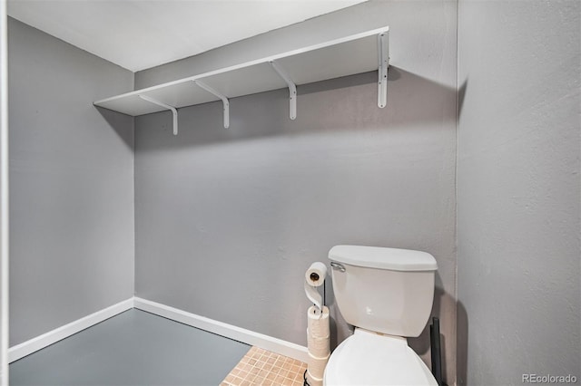 bathroom with toilet and baseboards