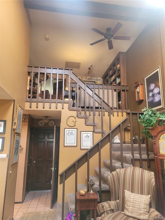 stairs featuring ceiling fan and tile patterned floors