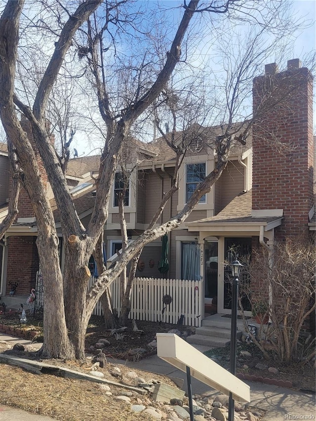 view of front of property featuring roof with shingles and a chimney