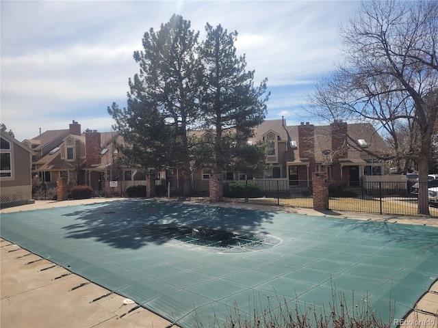 view of pool featuring fence and a residential view