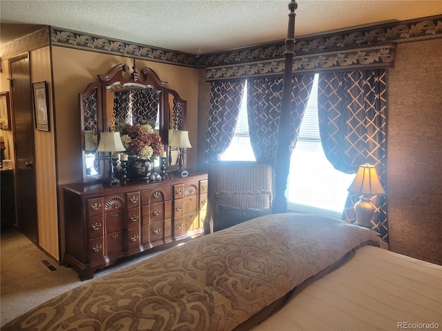 bedroom featuring carpet, visible vents, and a textured ceiling