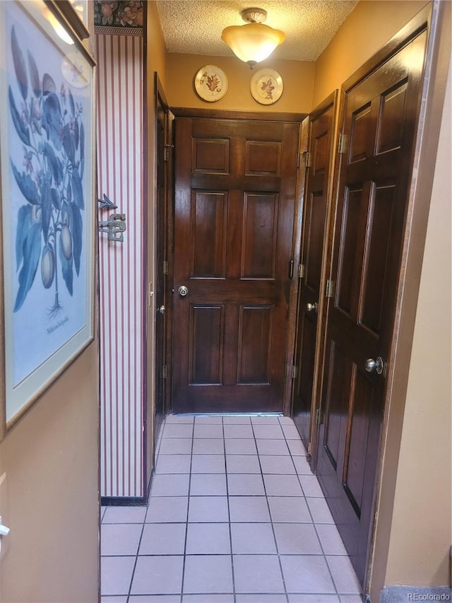 entryway with light tile patterned floors and a textured ceiling