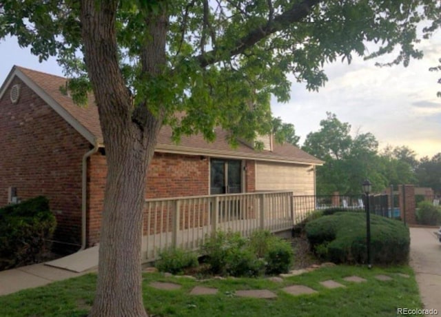 14282 E Radcliff Cir, Aurora, CO 80015 - view of home's exterior featuring brick siding, a wooden deck, and a yard