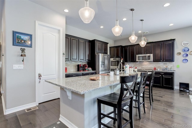 4767 S Odessa St, Centennial, CO 80015 - kitchen featuring stainless steel appliances, recessed lighting, tasteful backsplash, a kitchen breakfast bar, and baseboards