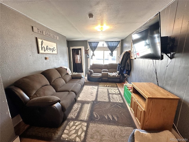 living room featuring wood walls and a textured ceiling