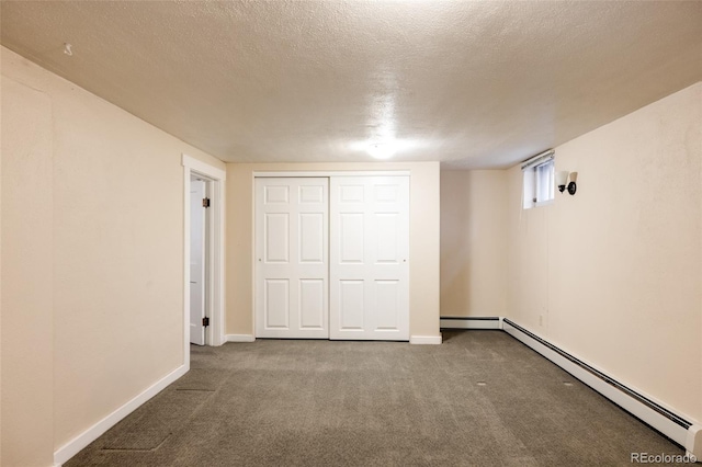 unfurnished bedroom with carpet, baseboards, baseboard heating, and a textured ceiling