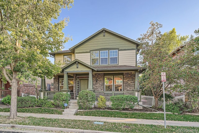 5892 W 94th Pl, Westminster, CO 80031 - view of front of house featuring a porch, brick siding, and fence