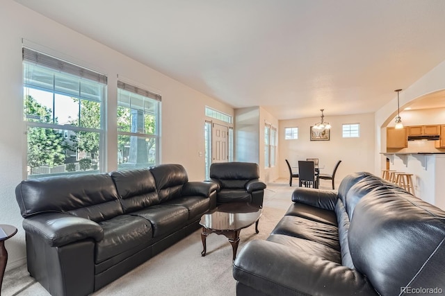 living room with an inviting chandelier and light colored carpet