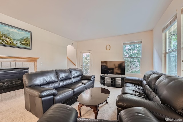 carpeted living room with a wealth of natural light and a tile fireplace