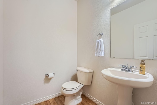 5892 W 94th Pl, Westminster, CO 80031 - half bathroom with wood finished floors, toilet, baseboards, and a sink