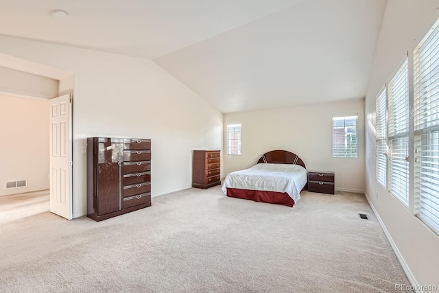 carpeted bedroom with lofted ceiling and multiple windows