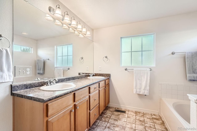 bathroom featuring vanity and a washtub