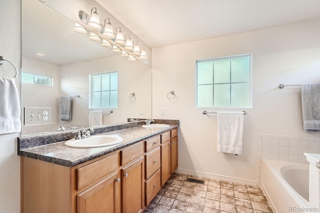 5892 W 94th Pl, Westminster, CO 80031 - bathroom with baseboards, double vanity, a bath, and stone finish flooring