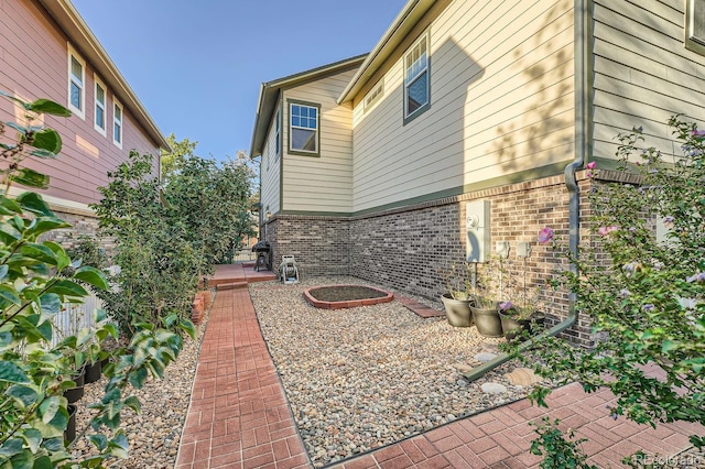 5892 W 94th Pl, Westminster, CO 80031 - view of side of home featuring brick siding and a patio
