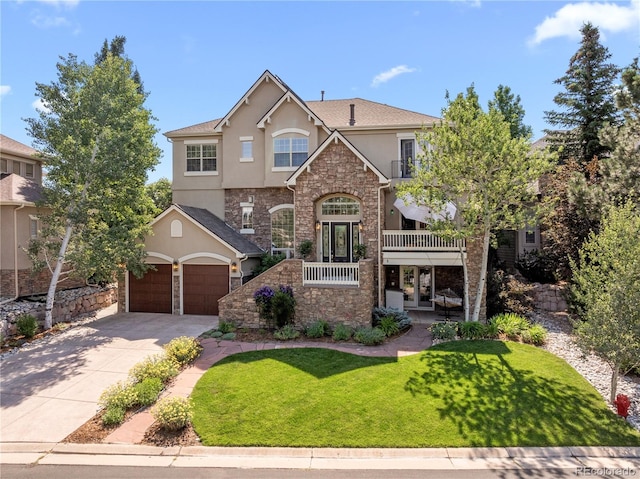 view of front of property with concrete driveway, stone siding, stucco siding, french doors, and a front yard