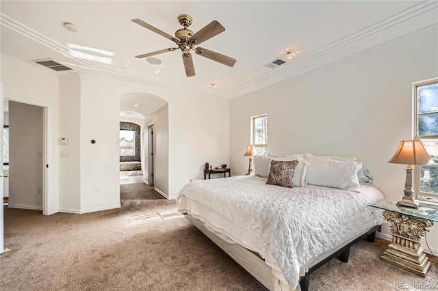 carpeted bedroom featuring arched walkways, visible vents, crown molding, and baseboards