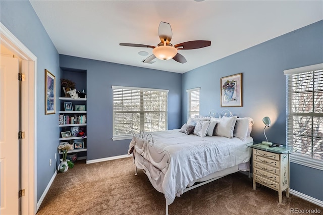 carpeted bedroom featuring multiple windows, ceiling fan, and baseboards