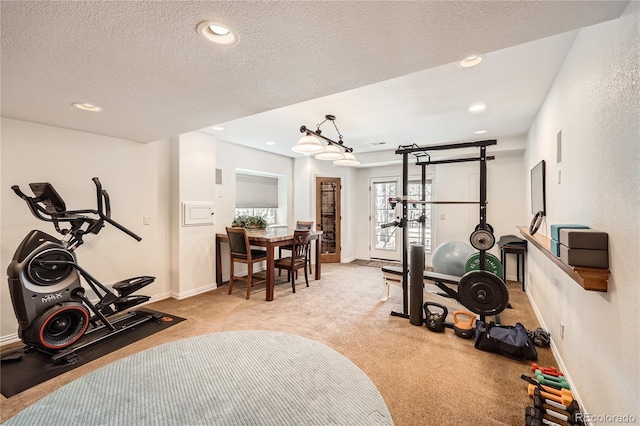 exercise area featuring recessed lighting, light colored carpet, a textured ceiling, and baseboards