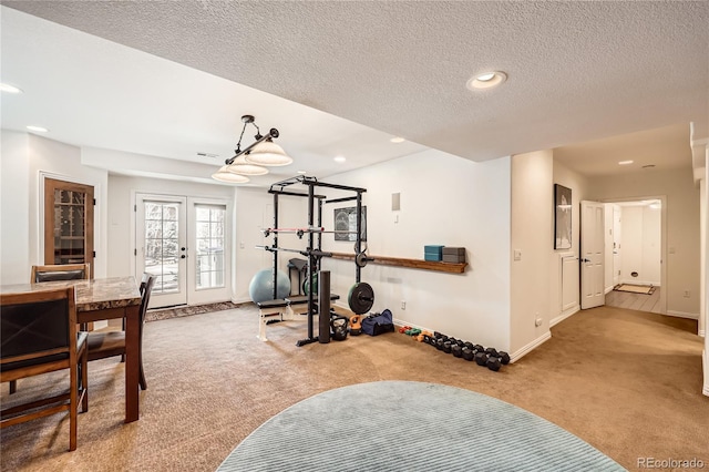 workout area featuring baseboards, carpet, a textured ceiling, french doors, and recessed lighting