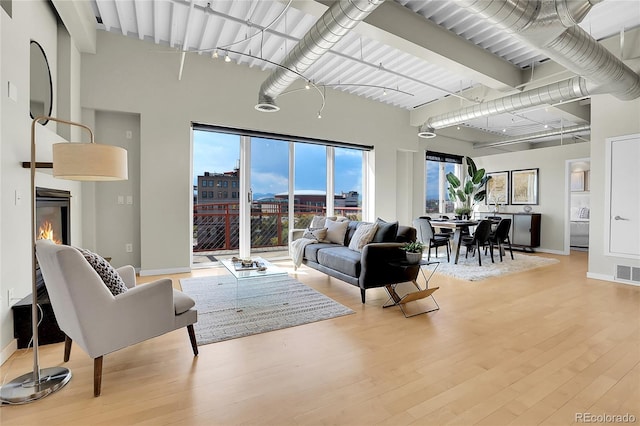 living room with light hardwood / wood-style floors and a high ceiling