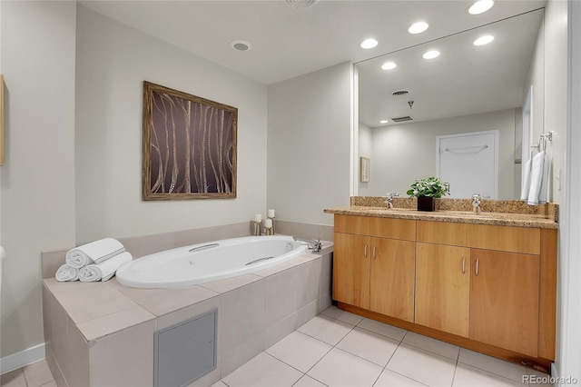 bathroom featuring a relaxing tiled tub, vanity, and tile patterned flooring