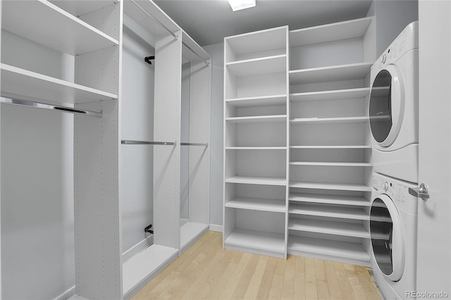 walk in closet featuring stacked washer / drying machine and wood-type flooring