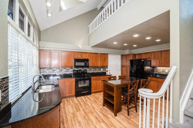 4218 E Flanders St, Denver, CO 80249 - kitchen with black appliances, dark countertops, tasteful backsplash, light wood-style flooring, and brown cabinets