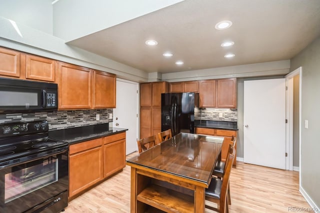 4218 E Flanders St, Denver, CO 80249 - kitchen with black appliances, dark countertops, decorative backsplash, light wood-style flooring, and recessed lighting