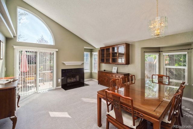 4218 E Flanders St, Denver, CO 80249 - dining area featuring light colored carpet, a chandelier, lofted ceiling, a textured ceiling, and a fireplace with flush hearth