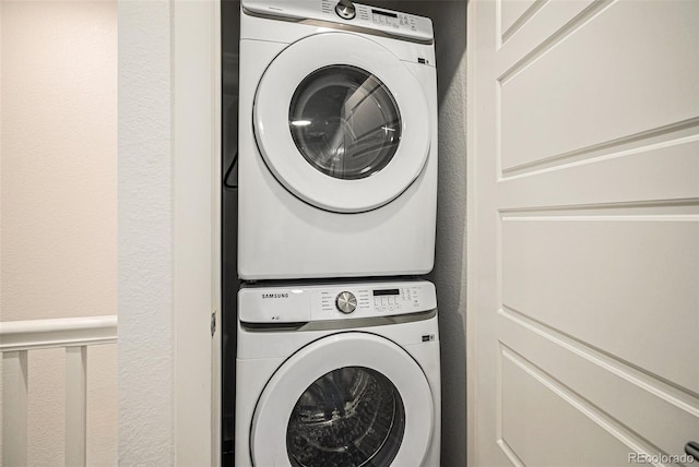 clothes washing area featuring stacked washer / dryer