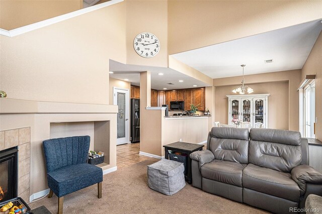 23235 York Ave, Parker, CO 80138 - living area featuring light colored carpet, a tiled fireplace, recessed lighting, a high ceiling, and a chandelier