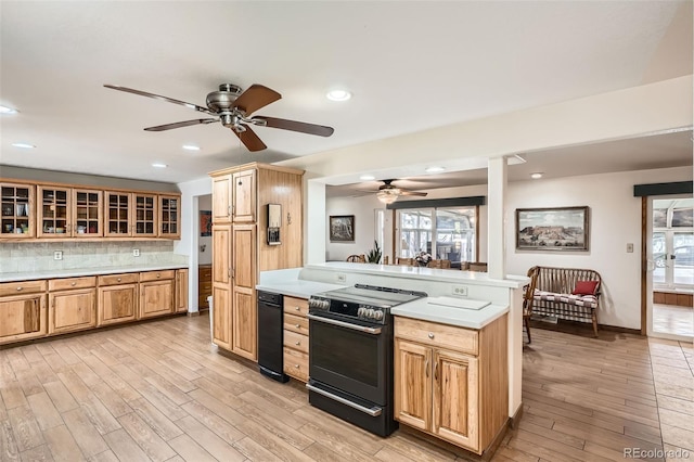 10223 W 77th Dr, Arvada, CO 80005 - kitchen with electric range, a ceiling fan, light countertops, light wood-style floors, and glass insert cabinets