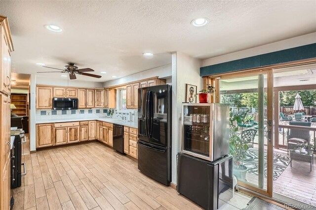 10223 W 77th Dr, Arvada, CO 80005 - kitchen with black appliances, a ceiling fan, light countertops, light wood-type flooring, and backsplash