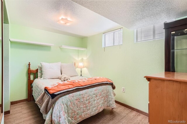 10223 W 77th Dr, Arvada, CO 80005 - bedroom featuring wood finished floors and a textured ceiling
