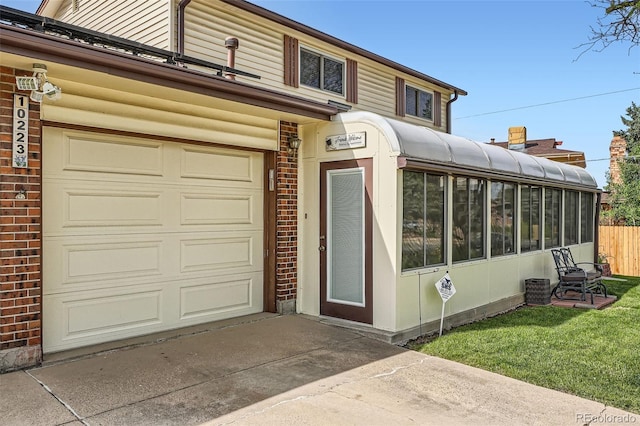 10223 W 77th Dr, Arvada, CO 80005 - view of front of home with a sunroom, driveway, and an attached garage