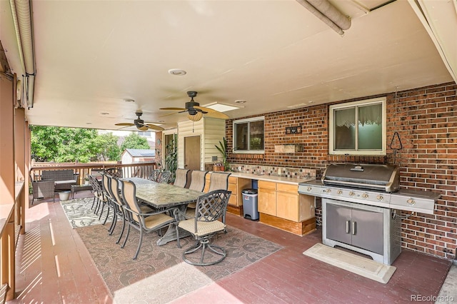 10223 W 77th Dr, Arvada, CO 80005 - view of patio featuring area for grilling, outdoor dining space, a wooden deck, ceiling fan, and a storage shed