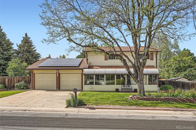 10223 W 77th Dr, Arvada, CO 80005 - traditional-style home with a sunroom, an attached garage, roof mounted solar panels, driveway, and a shingled roof