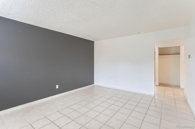 tiled empty room with a textured ceiling